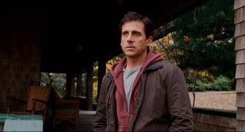 Movie still from “Dan in Real Life” (2007), directed by Peter Hedges – A man in a brown and red jacket standing in front of trees; Medium shot, Over the shoulder angle