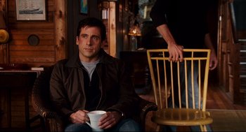 Movie still from “Dan in Real Life” (2007), directed by Peter Hedges – A man sitting in a chair holding a coffee cup; Medium shot, Over the shoulder angle