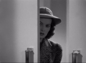 Movie still from “Dance, Girl, Dance” (1940), directed by Roy Del Ruth – A black and white photo of a woman wearing a hat; Medium shot, Over the shoulder angle