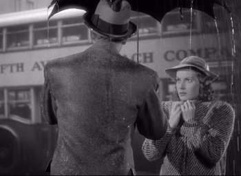 Movie still from “Dance, Girl, Dance” (1940), directed by Roy Del Ruth – A man and a woman under an open umbrella; Medium shot, Low angle