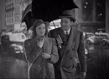 Movie still from “Dance, Girl, Dance” (1940), directed by Roy Del Ruth – A man and a woman walking under an umbrella in the rain; Medium shot, Low angle