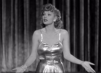 Movie still from “Dance, Girl, Dance” (1940), directed by Roy Del Ruth – A black and white photo of a woman in a silver dress; Medium shot, Low angle