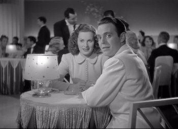 Movie still from “Dance, Girl, Dance” (1940), directed by Roy Del Ruth – A man and a woman sitting at a dinner table; Medium shot, Low angle
