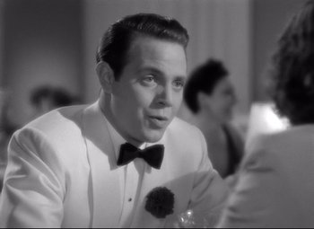 Movie still from “Dance, Girl, Dance” (1940), directed by Roy Del Ruth – A black and white photo of a man in a tuxedo; Close Up shot, Over the shoulder angle