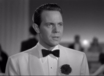 Movie still from “Dance, Girl, Dance” (1940), directed by Roy Del Ruth – A black and white photo of a man in a tuxedo; Close Up shot, Over the shoulder angle