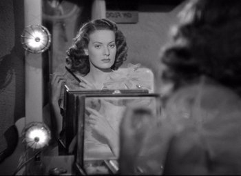 Movie still from “Dance, Girl, Dance” (1940), directed by Roy Del Ruth – A black - and - white photo of a woman looking at herself in a mirror; Close Up shot, Over the shoulder angle