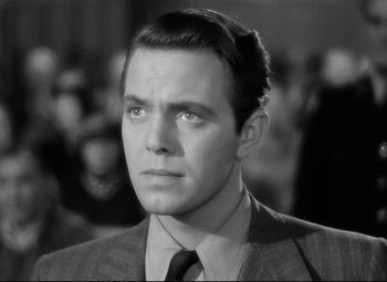 Movie still from “Dance, Girl, Dance” (1940), directed by Roy Del Ruth – Black and white photograph of a man in a suit and tie; Close Up shot, Low angle