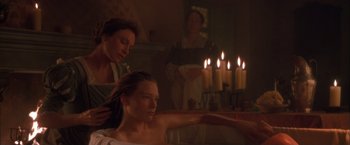 Movie still from “Dangerous Beauty” (1998), directed by Marshall Herskovitz – A woman in a bath tub next to another woman in front of a fireplace; Medium shot, High angle