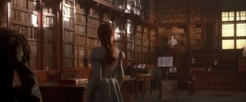 Movie still from “Dangerous Beauty” (1998), directed by Marshall Herskovitz – A woman standing in front of a book shelf; Medium shot, Low angle