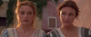 Movie still from “Dangerous Beauty” (1998), directed by Marshall Herskovitz – Two women are standing next to each other in front of a building; Close Up shot, Over the shoulder angle