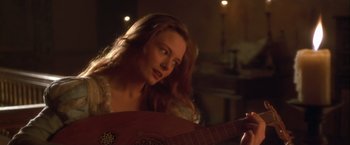 Movie still from “Dangerous Beauty” (1998), directed by Marshall Herskovitz – A beautiful young woman holding a guitar in a room; Close Up shot, Over the shoulder angle