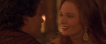 Movie still from “Dangerous Beauty” (1998), directed by Marshall Herskovitz – A woman smiles at a man in a red shirt; Close Up shot, Over the shoulder angle