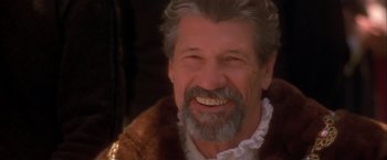 Movie still from “Dangerous Beauty” (1998), directed by Marshall Herskovitz – An older man with grey hair and a white beard smiling; Close Up shot, Over the shoulder angle