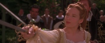 Movie still from “Dangerous Beauty” (1998), directed by Marshall Herskovitz – A woman in a white dress holding a flower; Close Up shot, Over the shoulder angle