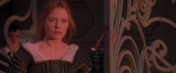 Movie still from “Dangerous Beauty” (1998), directed by Marshall Herskovitz – A young woman in medieval garb standing in front of a door; Close Up shot, Over the shoulder angle