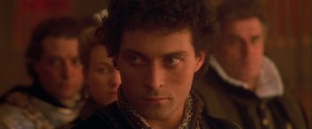 Movie still from “Dangerous Beauty” (1998), directed by Marshall Herskovitz – A person with a person in the background; Close Up shot, Over the shoulder angle