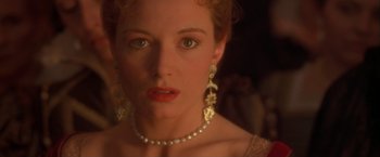 Movie still from “Dangerous Beauty” (1998), directed by Marshall Herskovitz – A person wearing a necklace and earrings; Close Up shot, Over the shoulder angle