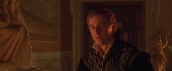 Movie still from “Dangerous Beauty” (1998), directed by Marshall Herskovitz – A young man in a black and white jacket looks at the camera; Close Up shot, Over the shoulder angle