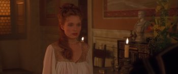 Movie still from “Dangerous Beauty” (1998), directed by Marshall Herskovitz – A woman in a white dress standing next to a table; Close Up shot, Over the shoulder angle