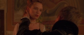 Movie still from “Dangerous Beauty” (1998), directed by Marshall Herskovitz – A young woman wearing a pearl necklace and looking at the camera; Close Up shot, Over the shoulder angle