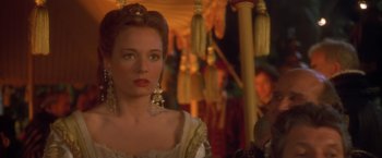 Movie still from “Dangerous Beauty” (1998), directed by Marshall Herskovitz – A woman in a white dress with a long earring; Close Up shot, Over the shoulder angle