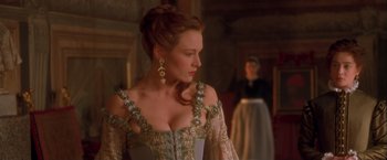 Movie still from “Dangerous Beauty” (1998), directed by Marshall Herskovitz – A woman wearing a dress and a long necklace; Medium shot, Over the shoulder angle