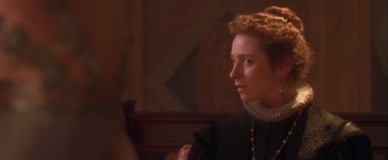 Movie still from “Dangerous Beauty” (1998), directed by Marshall Herskovitz – A woman in a black dress is looking to the side; Close Up shot, Over the shoulder angle
