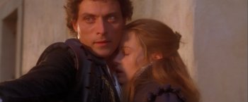 Movie still from “Dangerous Beauty” (1998), directed by Marshall Herskovitz – A man and a woman embracing each other in front of a brick wall; Close Up shot, High angle