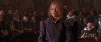 Movie still from “Dangerous Beauty” (1998), directed by Marshall Herskovitz – A woman in a blue coat standing in front of a crowd; Medium shot, Over the shoulder angle