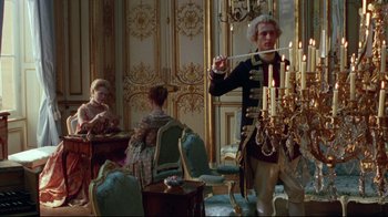 Movie still from “Dangerous Liaisons” (1988), directed by Stephen Frears – A group of people sitting in a room with chandeliers; Wide shot, High angle