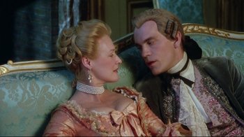 Movie still from “Dangerous Liaisons” (1988), directed by Stephen Frears – A man and a woman sitting next to each other on a couch; Close Up shot, Over the shoulder angle