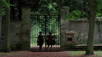 Movie still from “Dangerous Liaisons” (1988), directed by Stephen Frears – Two people are standing in front of a gate; Extreme Wide shot, Low angle