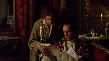 Movie still from “Dangerous Liaisons” (1988), directed by Stephen Frears – Two men are looking at a piece of paper and a candle; Medium shot, Over the shoulder angle