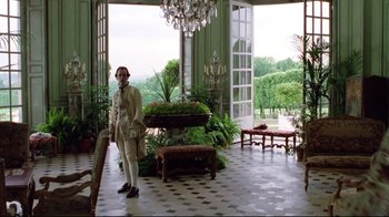 Movie still from “Dangerous Liaisons” (1988), directed by Stephen Frears – A man standing in front of a room filled with potted plants; Wide shot, Low angle