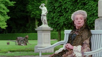 Movie still from “Dangerous Liaisons” (1988), directed by Stephen Frears – An older woman sitting on a chair in a garden; Medium shot, Low angle