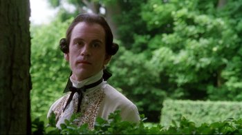 Movie still from “Dangerous Liaisons” (1988), directed by Stephen Frears – A man in white shirt and black tie standing in front of trees; Close Up shot, Low angle