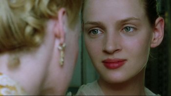 Movie still from “Dangerous Liaisons” (1988), directed by Stephen Frears – A woman looking into a mirror while wearing earrings; Close Up shot, Over the shoulder angle