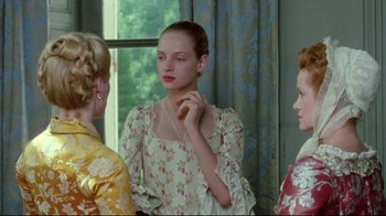 Movie still from “Dangerous Liaisons” (1988), directed by Stephen Frears – A woman in a floral dress looking at two other women; Medium shot, Over the shoulder angle
