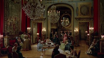 Movie still from “Dangerous Liaisons” (1988), directed by Stephen Frears – A group of people sitting in a room with chandeliers; Extreme Wide shot, High angle