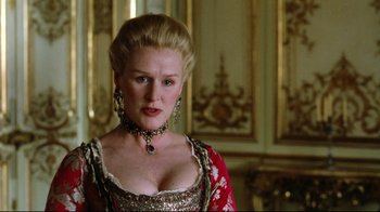 Movie still from “Dangerous Liaisons” (1988), directed by Stephen Frears – A woman in a red and gold dress with a necklace; Close Up shot, Low angle