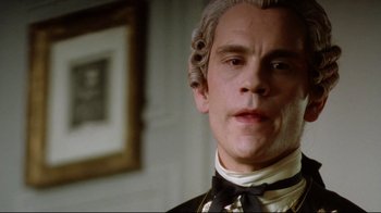 Movie still from “Dangerous Liaisons” (1988), directed by Stephen Frears – A person wearing a suit and bow tie; Close Up shot, Low angle
