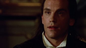 Movie still from “Dangerous Liaisons” (1988), directed by Stephen Frears – A man with long black hair wearing a white shirt; Close Up shot, Over the shoulder angle