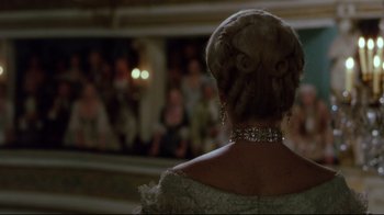 Movie still from “Dangerous Liaisons” (1988), directed by Stephen Frears – A woman in a white dress and a long necklace; Medium shot, Over the shoulder angle