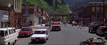 Movie still from “Dante's Peak” (1997), directed by Roger Donaldson – A street scene with cars parked on the side of the road; Extreme Wide shot, High angle
