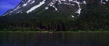 Movie still from “Dante's Peak” (1997), directed by Roger Donaldson – A house sitting on the side of a lake near a forest; Extreme Wide shot, High angle