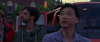 Movie still from “Dante's Peak” (1997), directed by Roger Donaldson – Two men sitting in the back seat of a car; Close Up shot, Low angle