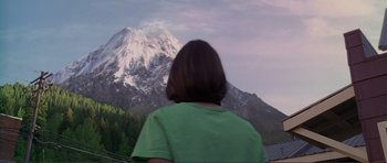 Movie still from “Dante's Peak” (1997), directed by Roger Donaldson – A woman standing in front of a snow covered mountain; Medium shot, Low angle