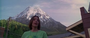 Movie still from “Dante's Peak” (1997), directed by Roger Donaldson – A woman standing in front of a snow covered mountain; Close Up shot, Low angle