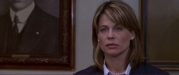 Movie still from “Dante's Peak” (1997), directed by Roger Donaldson – A person wearing a suit and pearls; Close Up shot, Over the shoulder angle