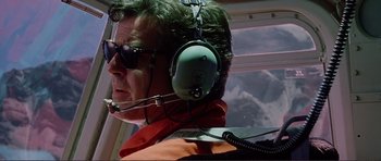 Movie still from “Dante's Peak” (1997), directed by Roger Donaldson – A man with a headset on in a helicopter; Medium shot, Low angle